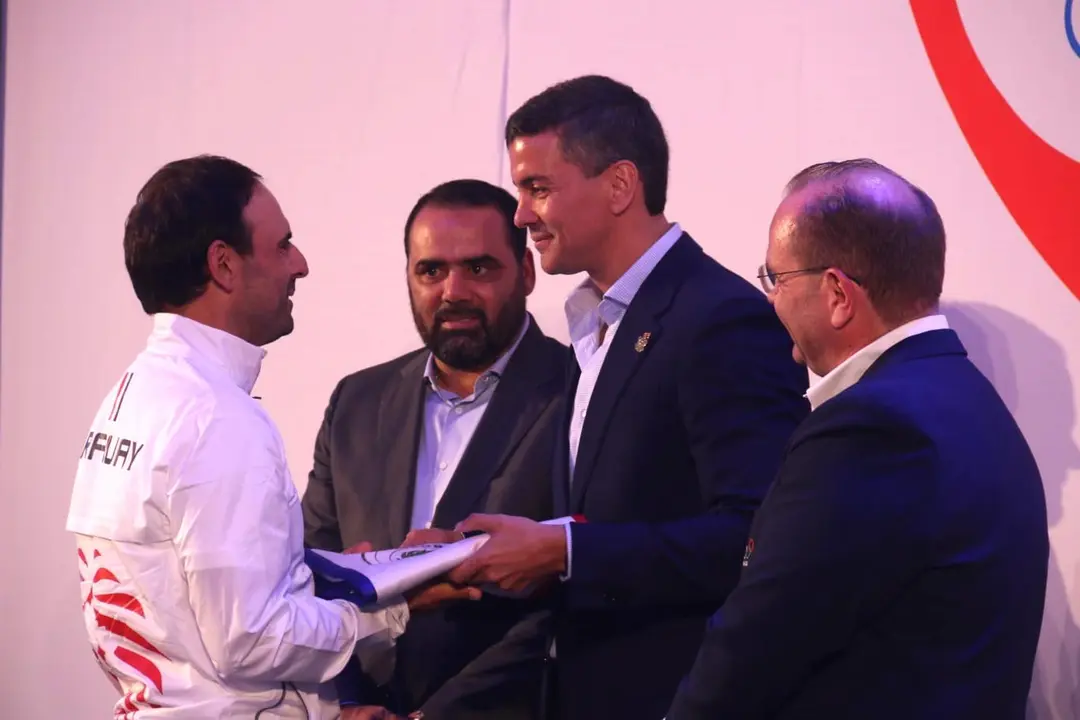 El presidente de Paraguay, Santiago Pe&ntilde;a (c), entrega la bandera del pa&iacute;s al golfista Fabrizio Zanotti, que encabezar&aacute; la delegaci&oacute;n de 30 deportistas que participar&aacute;n en los Juegos Ol&iacute;mpicos que se celebrar&aacute;n en Par&iacute;s del 26 de julio al 11 de agosto. EFE/Nina Osorio