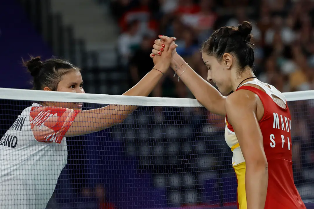 La jugadora de b&aacute;dminton espa&ntilde;ola Carolina Mar&iacute;n estrecha la mano a la suiza Jenjira Stadelmann (i) tras ganar su partido de la fase de grupos de la competici&oacute;n de b&aacute;dminton femenino individual de los Juegos Ol&iacute;mpicos de Par&iacute;s 2024 este domingo en el pabell&oacute;n Arena Porte de Chapelle en Par&iacute;s, Francia. Mar&iacute;n ha ganado por 21-11 y 21-19. EFE/ Julio Mu&ntilde;oz