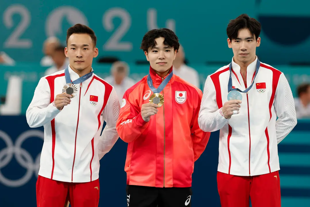 Los medallistas, el japon&eacute;s Shinnosuke Oka (c-oro), y los chinos, Boheng Zhang (plata-d) y Routeng Xiao (i-bronce), posan en la final de Concurso Completo Masculino de Gimnasia Art&iacute;stica, parte de los Juegos Ol&iacute;mpicos de Par&iacute;s 2024 este mi&eacute;rcoles, en el Bercy Arena de la capital francesa. EFE/ Julio Mu&ntilde;oz