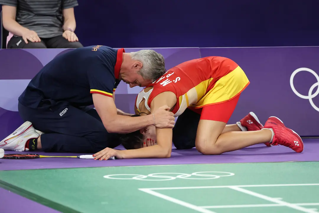 Carolina Mar&iacute;n recibe es consolada por su entrenador Fernando Rivas (i) tras lesionarse en la rodilla derecha durante su partido de semifinales de b&aacute;dminton ante He Bing Jiao, de China. EFE/ Miguel Guti&eacute;rrez