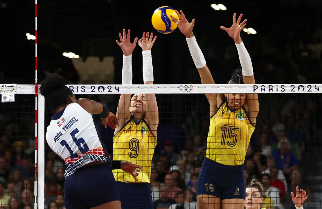 La dominicana Paola Pe&ntilde;a (i) trata de superar el bloqueo de ls brasile&ntilde;as Silva Ratzke (c) y Carolina da Silva (d) durante el partido de cuartos de final del torneo ol&iacute;mpico. EFE/EPA/DIVYAKANT SOLANKI