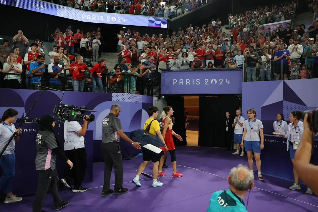La jugadora espa&ntilde;ola Carolina Mar&iacute;n (c) abandona la pista seguida de la china Bing Jiao He, tras verse obligada a retirarse, debido a una lesi&oacute;n, en el pabell&oacute;n a Chapelle Arena en la capital francesa. EFE/ Miguel Guti&eacute;rrez