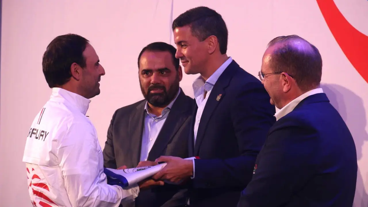El presidente de Paraguay, Santiago Pe&ntilde;a (c), entrega la bandera del pa&iacute;s al golfista Fabrizio Zanotti, que encabezar&aacute; la delegaci&oacute;n de 30 deportistas que participar&aacute;n en los Juegos Ol&iacute;mpicos que se celebrar&aacute;n en Par&iacute;s del 26 de julio al 11 de agosto. EFE/Nina Osorio