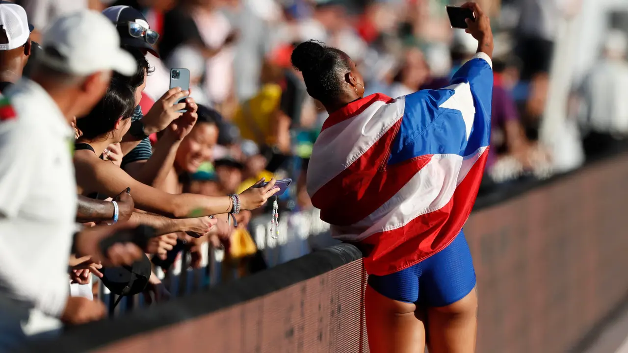 Fotograf&iacute;a de archivo, tomada el 24 de julio de 2022, en la que se registr&oacute; a la atleta puertorrique&ntilde;a Jasmine Camacho-Quinn (d), al posar para una foto con aficionados, tras lograr la medalla de bronce en la final de la prueba femenina de los 100 metros con vallas de los Campeonatos Mundiales de Atletismo, en Eugene (Oregon, EE.UU.). EFE/Alberto Est&eacute;vez