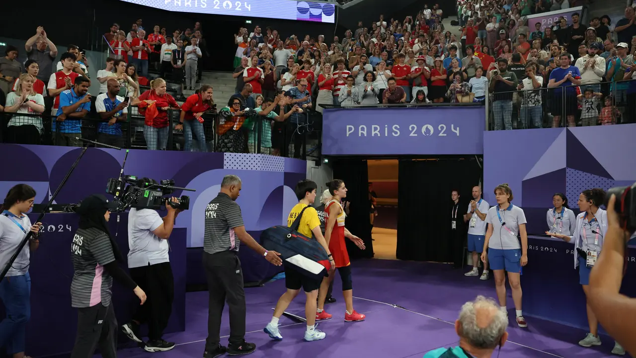 La jugadora espa&ntilde;ola Carolina Mar&iacute;n (c) abandona la pista seguida de la china Bing Jiao He, tras verse obligada a retirarse, debido a una lesi&oacute;n, en el pabell&oacute;n a Chapelle Arena en la capital francesa. EFE/ Miguel Guti&eacute;rrez