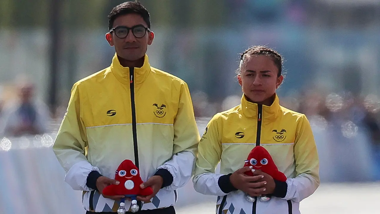Los atletas ecuatorianos Brian Daniel Pintado (i) y Glenda Morej&oacute;n (2i) posan tras ganar la plata en la prueba de marat&oacute;n mixto de marcha. EFE/ Miguel Guti&eacute;rrez