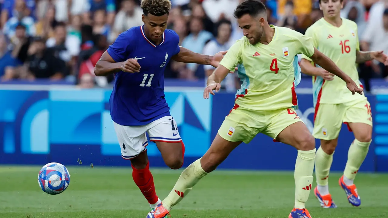 El jugador franc&eacute;s Desir&eacute; Doue (i) disputa un bal&oacute;n ante el jugador espa&ntilde;ol Eric Garc&iacute;a durante la prorroga del partido por la medalla de oro de los Juegos Ol&iacute;mpicos de Par&iacute;s 2024 que Francia y Espa&ntilde;a disputan este viernes en el Parc des Princes, de Paris . EFE/ JUANJO MARTIN