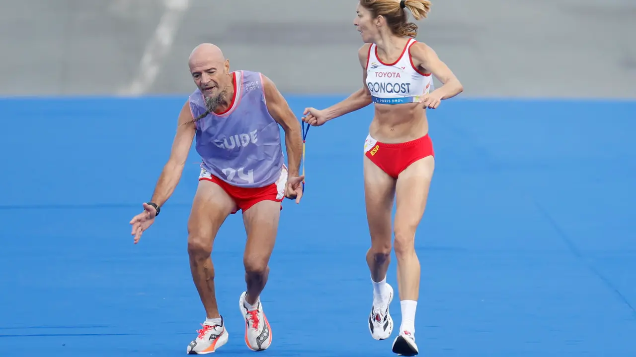 La atleta espa&ntilde;ola Elena Congost, medalla de bronce en la final de la marat&oacute;n T12 femenino, ayuda a su gu&iacute;a, que llega exhausto a la l&iacute;nea de meta, en los Juegos Paral&iacute;mpicos de Par&iacute;s 2024. Congost fue descalificada por soltar la cuerda que la un&iacute;a a su gu&iacute;a, Mia Carol Bruguera, que lleg&oacute; a la recta final con calambres y sufriendo en los &uacute;ltimos metros. EFE/ Javier Etxezarreta